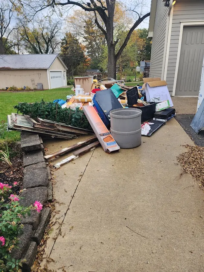 Dumpster being loaded with debris for Estate Cleanout Dumpster Rental in Bridge City